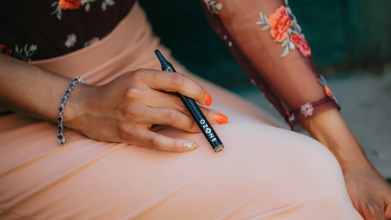 Woman holding a Ozone Vape.