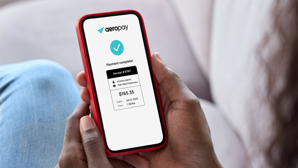 Hands holding red smart phone with Aeropay receipt displayed on the screen