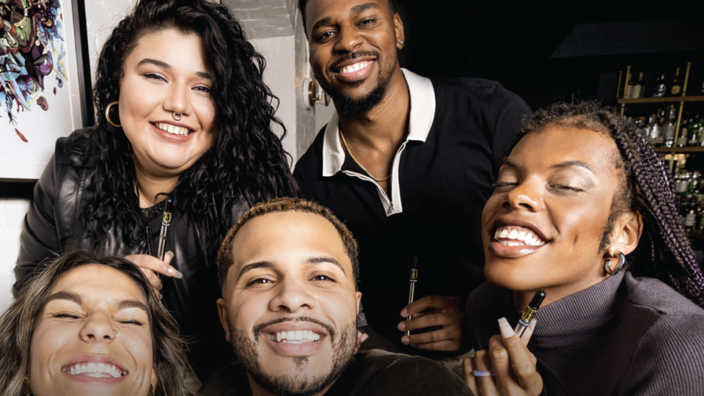 A diverse group of smiling adults holding cannabis vape pens, representing New Jersey weed culture.