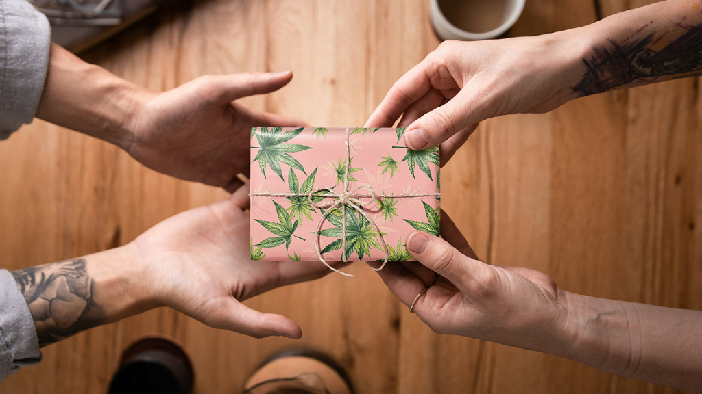 Hands exchanging a cannabis-themed birthday gift at High Street Dispensary