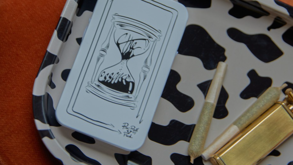 Pre-rolled joints and lighter on a black-and-white rolling tray with illustrated packaging
