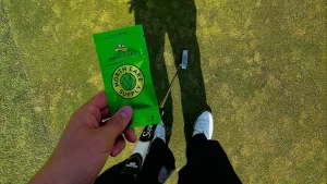 Hand holding a North Lake Supply 2g disposable cart vape on a golf green, showcasing on-the-go cannabis convenience.