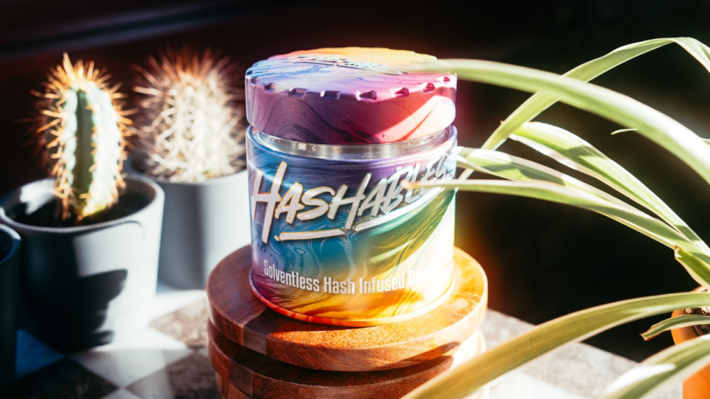 Colorful Hashables solventless edibles jar surrounded by houseplants and sunlight